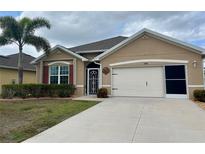 Charming single-story home featuring a well-maintained lawn, neutral paint, and an attached two-car garage at 7508 Mikasa Dr, Punta Gorda, FL 33950