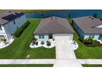 Beautiful single-Gathering home with a two-car garage, well-manicured lawn, and elegant landscaping near lake at 8232 Reefbay Cv, Parrish, FL 34219