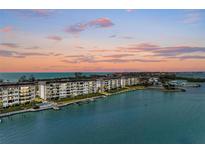 Stunning aerial view of waterfront condos with boat docks and beautiful sunset at 8977 Midnight Pass Rd # 519, Sarasota, FL 34242