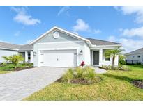 Exterior of home showing garage and entry with garden and lawn at 12570 Brookgreen St, Venice, FL 34293