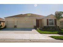Inviting single-story home featuring a three-car garage, well-maintained lawn, and desirable curb appeal at 15543 Trinity Fall Way, Bradenton, FL 34212