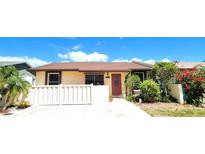 Charming single-story home with a well-manicured front yard and a welcoming red front door at 3915 40Th W St, Bradenton, FL 34205