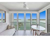 Bright living space with water views, light wood floors, and a ceiling fan for a cozy ambiance at 4310 Falmouth Dr # 305, Longboat Key, FL 34228
