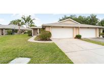 Charming home featuring an attached garage and a well-manicured lawn at 5689 Evergreen Dr # 18, Sarasota, FL 34233