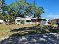 Charming single-story home featuring mature trees, a cozy porch, and a well-maintained lawn at 6324 Case Ave, Bradenton, FL 34207