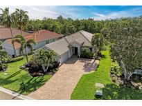 Beautiful single-story home with a tile roof, brick driveway, mature landscaping, and a two-car garage at 643 Misty Pond Ct, Bradenton, FL 34212