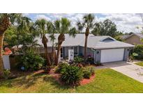 Charming single-story home featuring a well-manicured front yard, lush landscaping, and a two-car garage at 6583 Waterford Cir, Sarasota, FL 34238