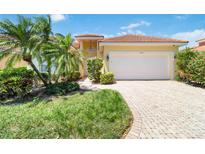 Inviting single-Gathering home featuring a light yellow exterior, a red tile roof, and a paver driveway and walkway at 7270 Alicante Dr # 3, Sarasota, FL 34238