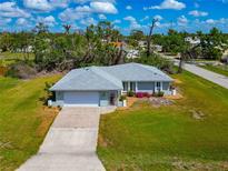 Charming single-story home with a well-manicured lawn, a long driveway and lovely curb appeal at 8152 Seashell St, Englewood, FL 34224