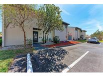 Inviting townhome exterior featuring a well-maintained lawn, mature trees, and convenient parking at 1026 Longfellow Ct # 111, Sarasota, FL 34243