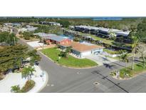 Aerial view of single-story home, showcasing lush landscaping and neighborhood canal access at 10304 Sandpiper W Rd, Bradenton, FL 34209