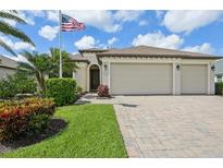 Charming single-story home with a well-manicured lawn, a two-car garage, and an American flag at 12210 Goldenrod Ave, Bradenton, FL 34212
