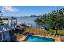 Beautiful backyard featuring a brick pool, a dock with boat, and scenic waterfront views, perfect for relaxation and enjoying coastal living at 1479 Bay Point Dr, Sarasota, FL 34236