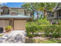 Charming townhome featuring a one-car garage, well-maintained landscaping, and inviting curb appeal at 1490 Mahogany Ln # 706, Palm Harbor, FL 34683