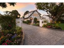 Charming two-story home with Tudor details, beautiful landscaping, and a paved driveway leading to the garage at 1829 Bougainvillea St, Sarasota, FL 34239