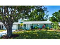Charming single-story home featuring a well-maintained lawn, mature trees, and colorful landscaping at 2238 Rose St, Sarasota, FL 34239