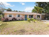 Charming single-story home with a lush front yard and a bright blue front door at 2922 Williamsburg St, Sarasota, FL 34231