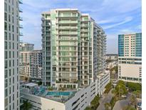 Modern high-rise condo exterior showcasing a pool, balconies, and stylish architectural design at 301 Quay Commons # 1204, Sarasota, FL 34236