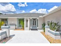 Charming front entrance with decorative glass door, light-blue trim and well-maintained landscaping, creating a welcoming curb appeal at 4487 Glebe Farm Rd, Sarasota, FL 34235