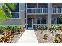 Charming condo with covered porch, lush landscaping, and well-maintained walkway at 5320 Hyland Hills Ave # 2214, Sarasota, FL 34241