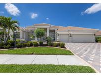 Stunning single-story home with a paver driveway and three-car garage, surrounded by lush landscaping and a tile roof at 7031 Scrub Jay Dr, Sarasota, FL 34241