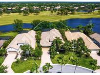 Stunning aerial view of a luxury home with a tile roof, lush landscaping, and waterfront golf course views at 7229 Lake Forest Gln, Lakewood Ranch, FL 34202