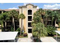 Condominium building with well-maintained grounds, palm trees, covered parking and secure entry at 7705 Grand Estuary Trl # 206, Bradenton, FL 34212