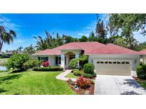 Well-maintained single Gathering home features lush landscaping, mature trees, and a brick walkway at 9238 13Th Avenue Nw Cir, Bradenton, FL 34209