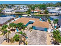 Stunning waterfront home with lush landscaping, a paver driveway, and a serene canal view at 10016 Spoonbill E Rd, Bradenton, FL 34209