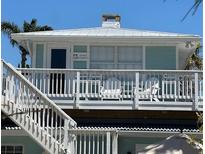 Inviting two-story beach house featuring a cozy balcony with relaxing chairs and ample natural light at 104 29Th St # 3, Holmes Beach, FL 34217