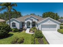Charming single-story home with a well-manicured lawn, two-car garage, and light-blue exterior at 12005 Summer Meadow Dr, Lakewood Ranch, FL 34202