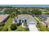 Inviting single-story home featuring manicured landscaping, an attached two-car garage, and a serene waterfront view at 12005 Summer Meadow Dr, Lakewood Ranch, FL 34202