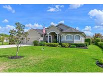Charming single-story home featuring lush green lawn, manicured landscaping, and neutral color palette at 15451 27Th E Ct, Parrish, FL 34219