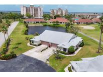 Stunning aerial view of home with pond, golf course, and nearby waterfront condos, offering serene Florida living at 1714 Fairway Trce, Palmetto, FL 34221
