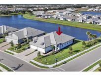 An aerial view of a charming single-Gathering home next to a lake in a well-maintained community at 17902 Cherished Loop, Lakewood Ranch, FL 34211