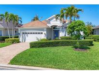 Beautiful single-story home boasts a manicured lawn, lush landscaping, and a two-car garage with a brick paver driveway at 1806 85Th Nw Ct, Bradenton, FL 34209