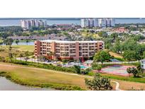 Beautiful condominium building with a pool and tennis court in a lush, green community at 2311 14Th W Ave # 208, Palmetto, FL 34221