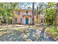 Charming two-story home featuring a turquoise front door, white columns, and a quaint second-story balcony at 2315 Mcclellan Pkwy, Sarasota, FL 34239
