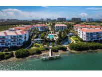 A beautiful aerial view showcases this waterfront condo community with a pool, dock, and manicured landscaping at 340 Gulf Of Mexico Dr # 124, Longboat Key, FL 34228