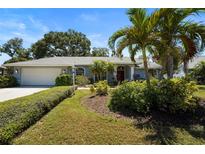 Charming single-story home with a well-manicured lawn, lush landscaping, and a two-car garage at 4449 Greenfield Ave, Sarasota, FL 34233