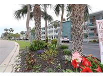 Condo complex view shows landscaping with flower beds in front of the building at 5888 17Th W St # C23, Bradenton, FL 34207
