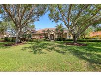 Beautiful single-story home with a tile roof, mature trees, and lush landscaping at 7441 Myrica Dr, Sarasota, FL 34241
