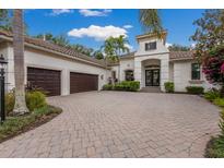 Stunning home featuring a well-manicured lawn, three-car garage, and an inviting double door entrance at 7532 Greystone St, Lakewood Ranch, FL 34202