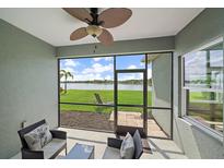 Enclosed lanai with beautiful views of the lake and comfortable seating area at 7743 Ridgelake Cir, Bradenton, FL 34203