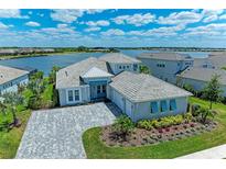 Stunning waterfront home boasts lush landscaping, a paved driveway, and a three-car garage at 8059 Waterbend Trl, Sarasota, FL 34240