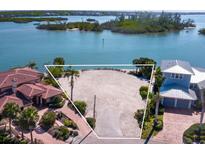 Expansive waterfront vacant lot showcasing stunning bay views and beautiful surrounding tropical landscaping at 894 Freeling Dr, Sarasota, FL 34242