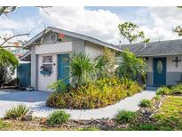 Charming single-story home with lush landscaping, walkway, and vibrant blue accent door at 1108 65Th W Ave, Bradenton, FL 34207