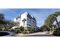 Exterior of a multi-story condominium building featuring modern architecture and lush landscaping around the property at 1255 E Peppertree Dr # 506, Sarasota, FL 34242
