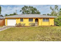 Charming yellow single-story home with an attached garage and well-maintained front lawn at 2151 Upton Ave, Sarasota, FL 34232