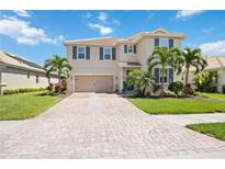 Charming two-story home featuring a brick driveway, lush landscaping and inviting curb appeal at 2177 Weaver Bird Ln, Venice, FL 34292